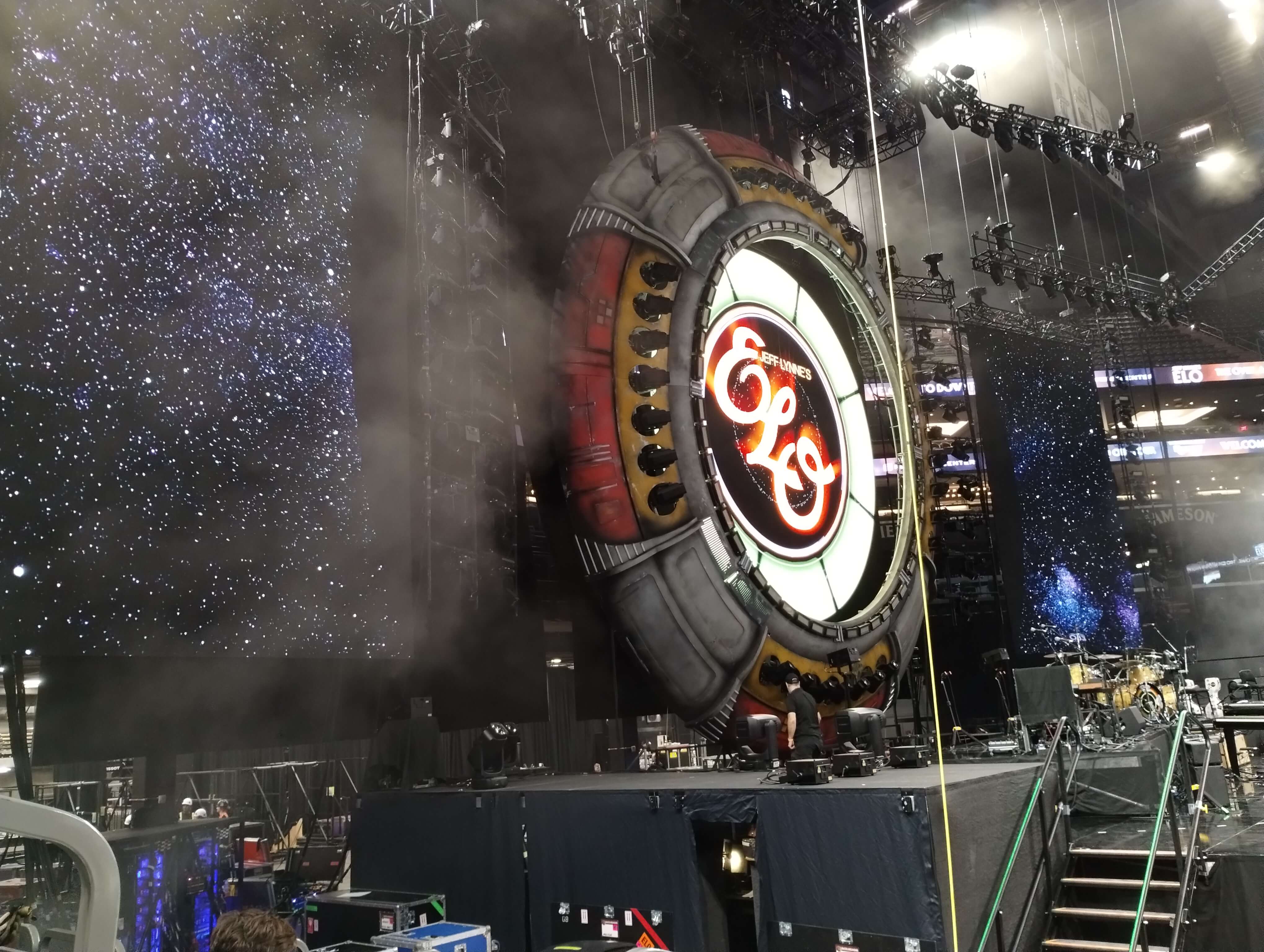 ELO's iconic illuminated spaceship stage with logo and atmospheric haze during show