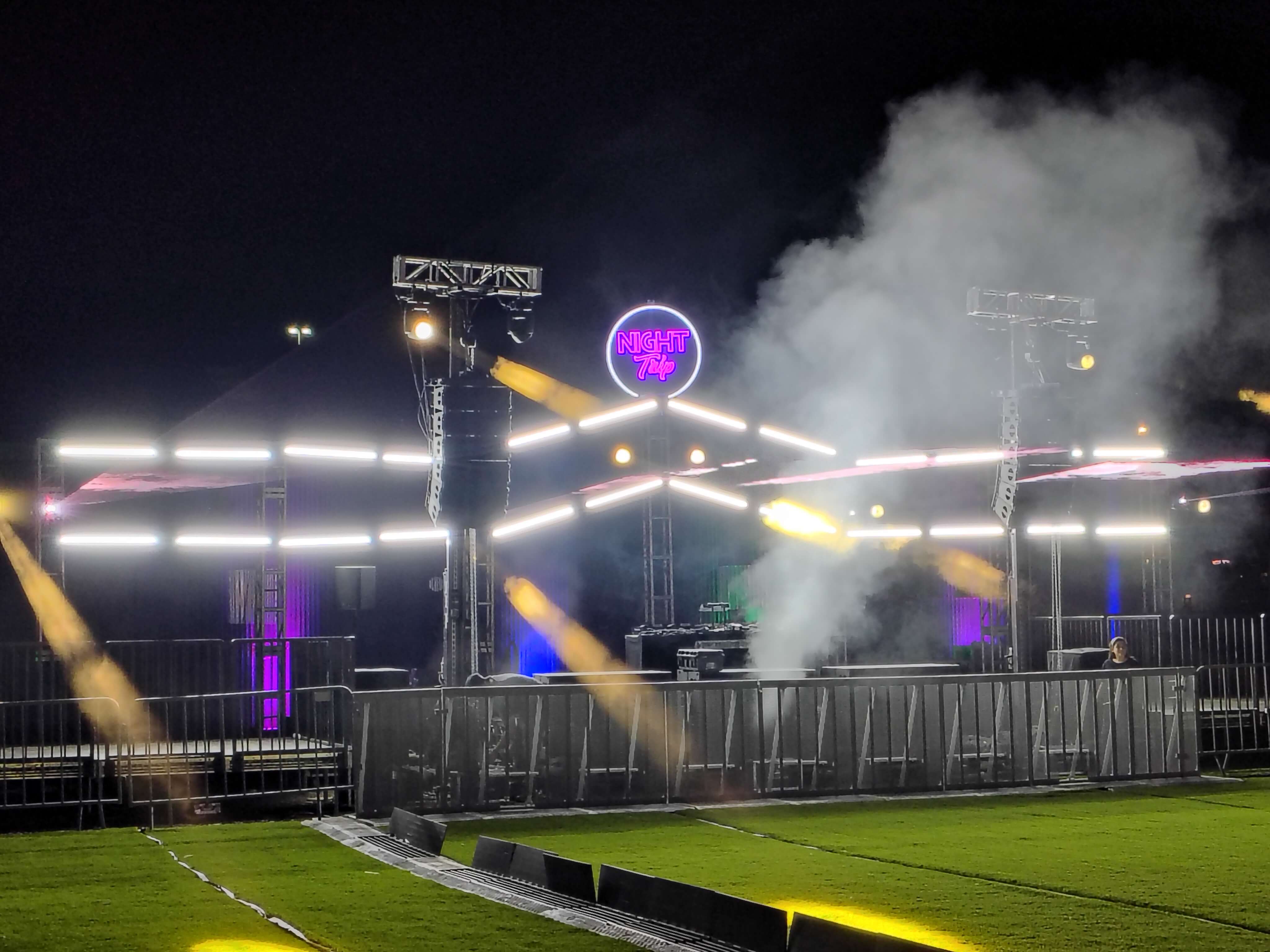 Night Trip by Relentless Beats festival stage lit at night with neon sign, moving lights, and atmospheric haze