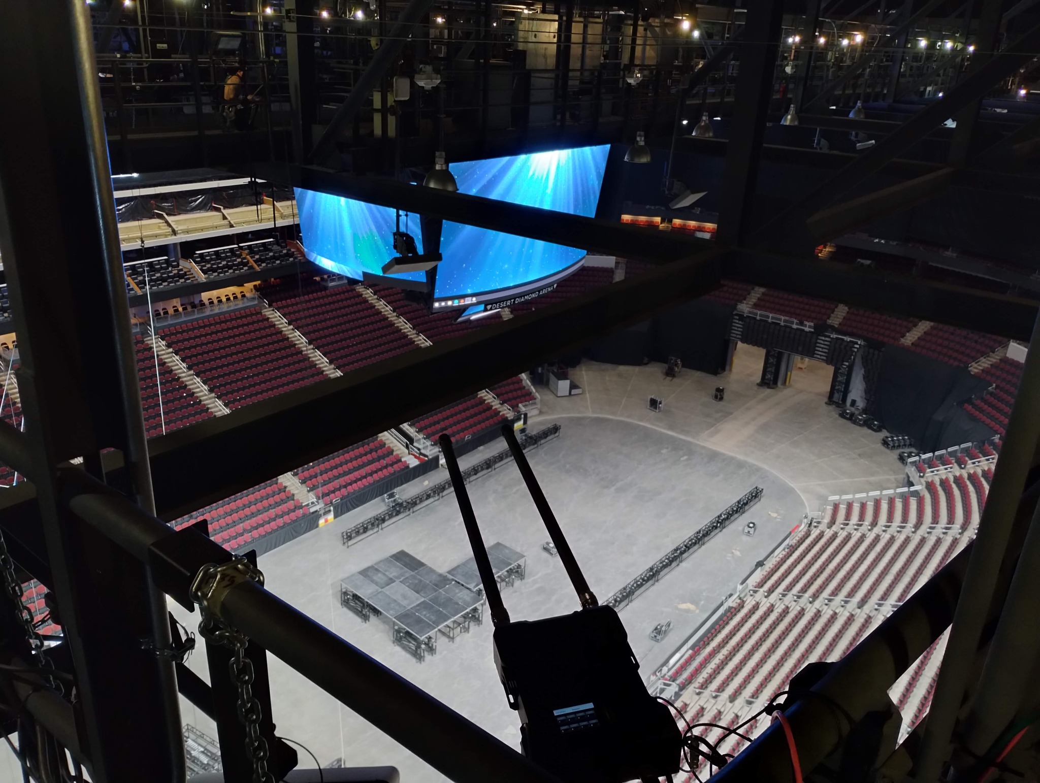 Followspot operator's view from the catwalk at Desert Diamond Arena looking down at the stage with a curved LED screen displaying an ocean scene